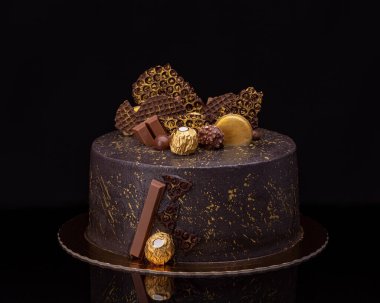 Siyah arka planda şekerli lezzetli çikolatalı pasta.