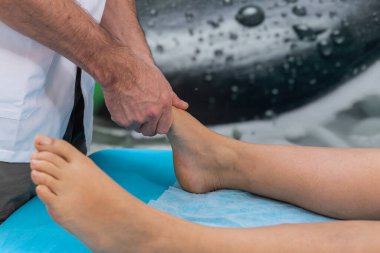 Osteopat terapisti hastaya ayak masajı ve manipülasyon yapar.