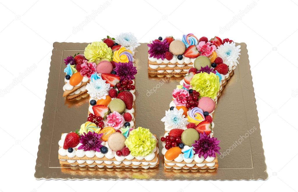 A cake in the shape of a figure sixteen of flowers and fruits