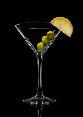 Zeytinli boş martini bardağının soyut fotoğrafı. Siyah bir arkaplanda