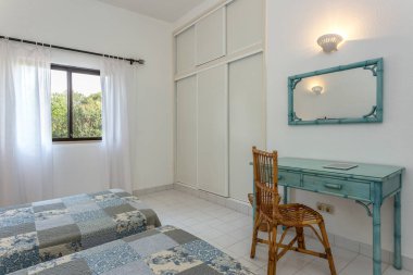 İki yataklı yatak odası, gardırop ve masa.