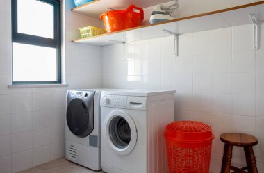 Çamaşır makinesi ve çamaşır kurutma makinesi olan bir çamaşır odası..