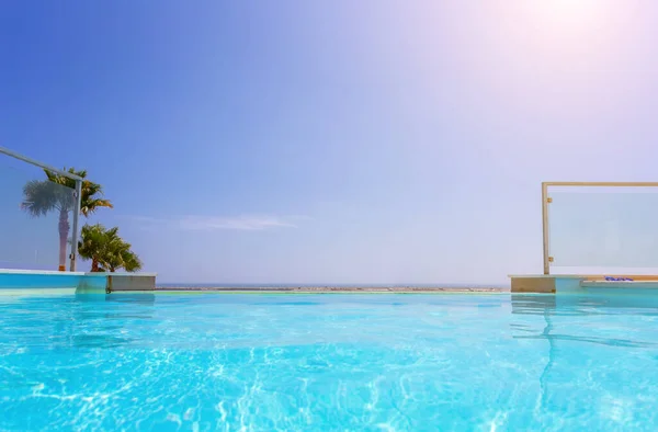 Piscina de lujo y agua azul en el complejo con hermosas vistas al mar . —  Fotos de Stock