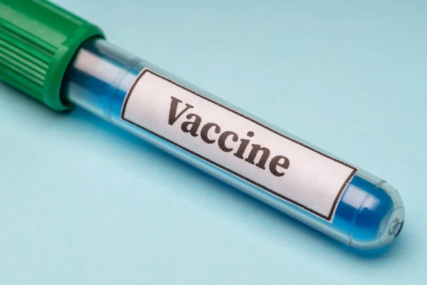 Tubo de laboratorio con vacuna contra el virus del coronavirus de la alergia sobre un fondo azul . — Foto de Stock