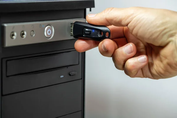 Insertar a mano una unidad flash USB en una computadora . — Foto de Stock