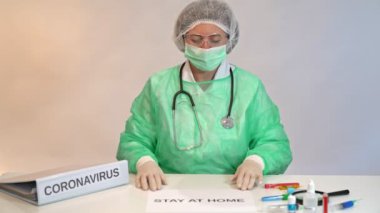 Doktor hemşire, devam eden koronavirüs testleri sırasında bir hastane laboratuvar kliniğindeki bir masada tehlikeye karşı uyardı..