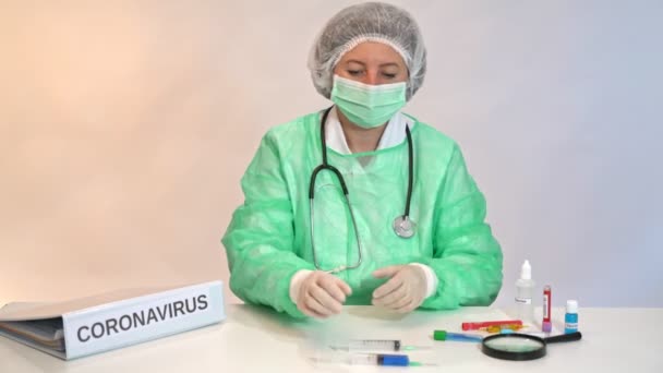 Arts verpleegkundige aan een tafel in een ziekenhuis laboratorium kliniek tijdens een coronavirus test. — Stockvideo