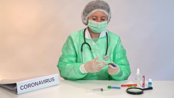 Läkarsköterska vid ett bord på en sjukhuslaboratorieklinik under ett coronavirus test. — Stockvideo