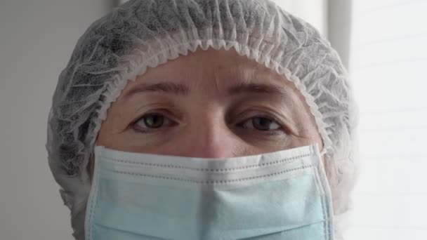 Vermoeide arts verpleegkundige na hard werken tijdens quarantaine voor coronavirus en allergieën. Close-up portret. — Stockvideo