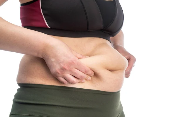 Woman with fat folds on her stomach. Conceptual image of obesity. Side view. Close-up, Isolated on a white background. — Stock Photo, Image
