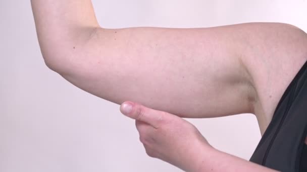 Žena středního věku s nadváhou drží ruku s přebytečným tukem. Na bílém pozadí, Izolované. — Stock video