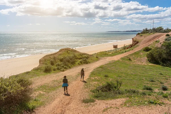 Dwie dziewczyny sportowców w mundurach sportowych, spacer wzdłuż brzegu klifu, w lecie w pobliżu morza. Plaża Falesia, Vilamoura Albufeira, Portugalia. — Zdjęcie stockowe