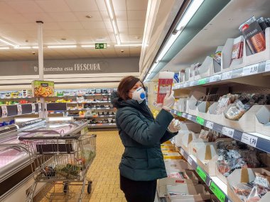 Portekiz Faro 2020 - Nisan: Bir süpermarketteki kadın Lidl, Coronavirus döneminde alışveriş arabası temel ürünleri satın alır.