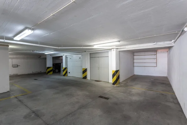 Κοινός χώρος στάθμευσης αυτοκινήτων σε πολυώροφο κτίριο με σωλήνες αποχέτευσης. — Φωτογραφία Αρχείου