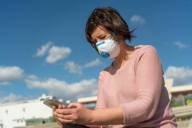 Koronavirüsten ve bahar alerjisinden kaynaklanan karantina sırasında yüzünde maske olan bir kadın..