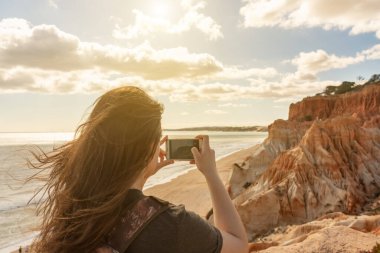 Portekiz 'in Atlantik Okyanusu kıyısında bir kız, deniz manzaraları, Algarve sahilleri, Falesia. Sıcak tonlama.