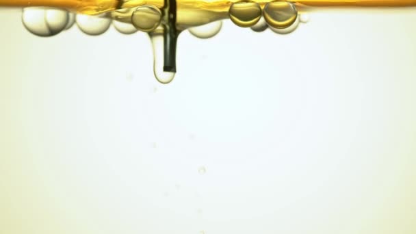 Fuel, yellow, golden oil is poured into a glass vessel through a tube in the laboratory dispensing bubbles. — Stock Video