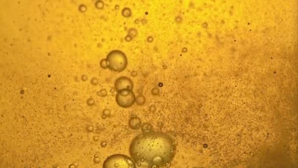 Combustible, aceite, amarillo dorado, con burbujas en movimiento, arriba y abajo, en el vaso de vidrio del laboratorio. Copiar espacio . — Vídeos de Stock