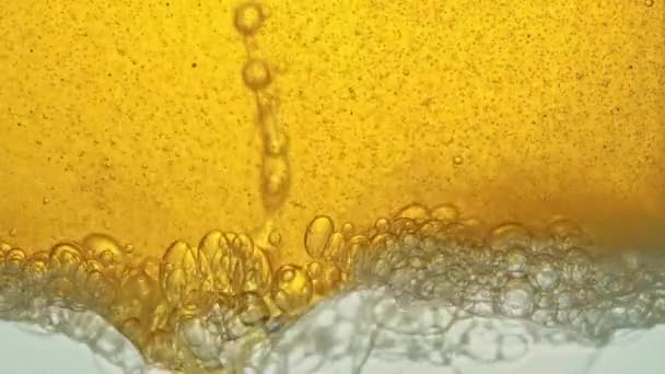 Fuel, yellow, golden oil, poured into a glass vessel in a laboratory, releases bubbles similar to foam. — Stock Video