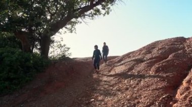 Başarılı, orta yaşlı bir kadın ve bir kayanın üzerinde spor yürüyüşü yapan genç bir kız, Cliff. Anne ve kızı..