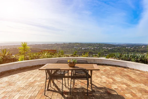 Holztisch mit Stühlen auf der Terrasse, Balkon mit Blick auf die Stadt. — Stockfoto