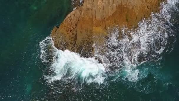 Nostalgické letecké video, ve zpomaleném pohybu moře, se vlny hladce valí po skalnatých březích Tichého oceánu. — Stock video