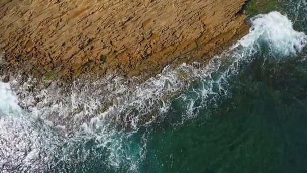 Nostalgické letecké video, ve zpomaleném pohybu moře, se vlny hladce valí po skalnatých březích Tichého oceánu. — Stock video