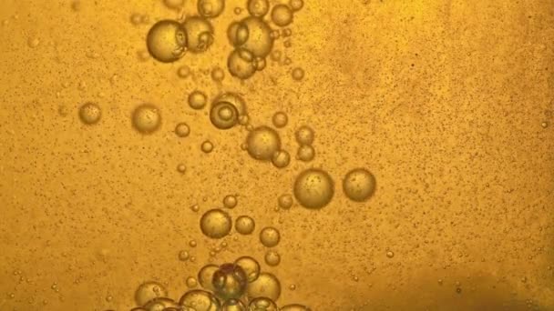 Топливо, масло, желтый золотистый оттенок, с движущимися пузырьками, вверх и вниз, в стеклянном сосуде лаборатории. Копирование пространства . — стоковое видео