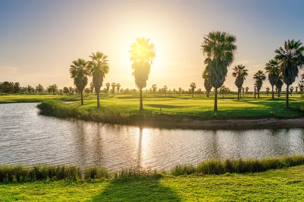 Bonito, com grama verde, campo de golfe, com uma lagoa, com céu azul ensolarado e claro. Portugal, Algarve . — Fotografia de Stock