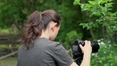 Genç bir kız, bir fotoğrafçı, bir derenin aktığı bir orman bölgesinde güzel doğa resimleri çekiyor..
