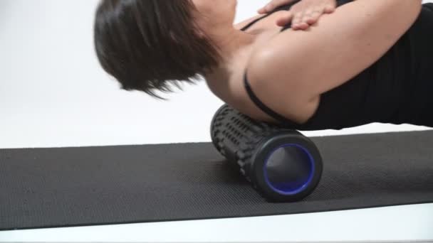 Egy középkorú nő gerincmasszázst végez a myofascial görgőn. Közelkép. — Stock videók