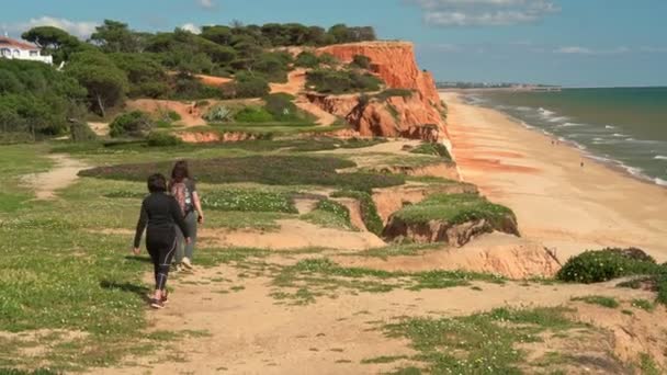 Sport donne di successo turisti passeggiando lungo una scogliera sull'oceano. Mamma con una figlia . — Video Stock