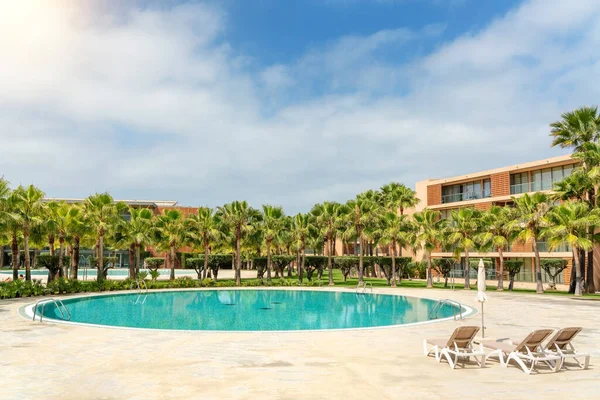 Modern luxurious pool with clean, clear, blue water and sun loungers