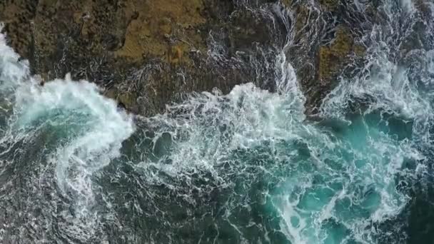 Vidéo aérienne nostalgique, au ralenti de la mer, les vagues roulent en douceur sur les rives rocheuses de l'océan Pacifique Atlantique. — Video