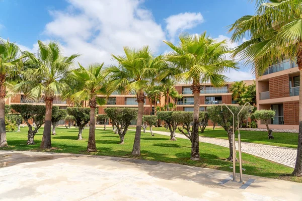 Modernes Hotel mit Palmen, grünem Gras und blauem Himmel. Portugal, Algarve. — Stockfoto