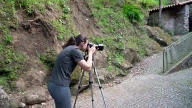 Genç bir kız, bir fotoğrafçı, bir orman bölgesinde, eski bir evin ve güzel bir doğanın fotoğraflarını çekiyor..