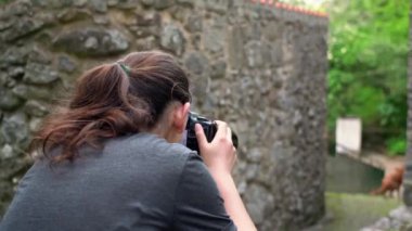 Genç bir kız, bir fotoğrafçı, bir orman bölgesinde, güzel doğa resimleri çekiyor. Yakın plan..