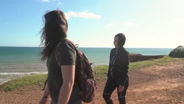 Sport framgångsrika kvinnor turister promenader längs en klippa på havet. Mamma med en dotter. — Stockvideo