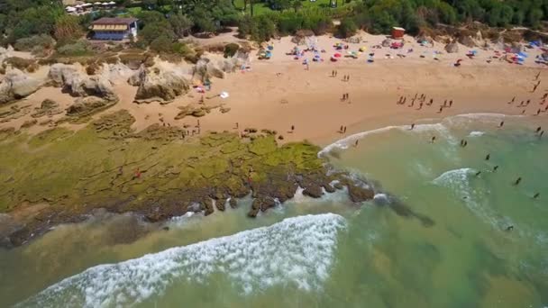 ポルトガルのガレの海岸、岩、ビーチの空中写真。観光客は、透明度の高いターコイズブルーの水で泳ぐ. — ストック動画