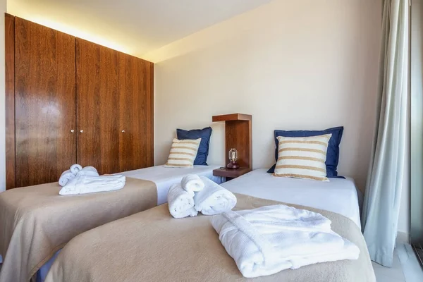 Dormitorio con una cama moderna y toallas en primer plano. Diseño de hotel europeo . — Foto de Stock