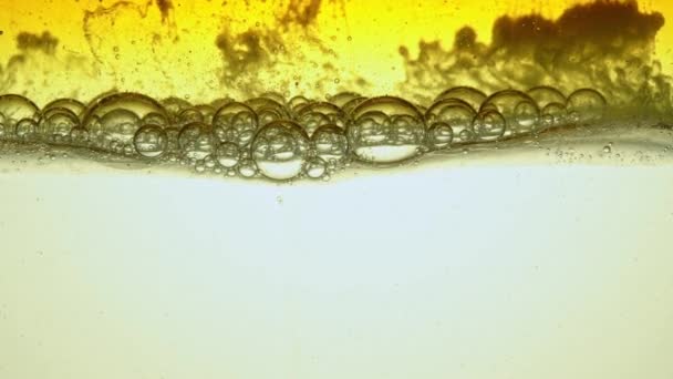Топливо, желтое, золотое масло, которое пузырьки в стеклянном сосуде в лаборатории в замедленной съемке . — стоковое видео