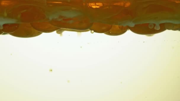 Combustible, aceite, tonalidad dorada amarilla, con burbujas grandes y pequeñas moviéndose hacia arriba, hacia abajo, en el recipiente pegado del laboratorio. Copiar espacio. — Vídeos de Stock
