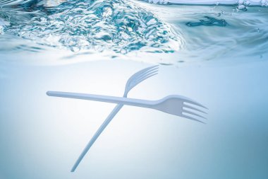 Küresel ekolojik sorun, çevresel kirlilik, denizlerdeki atıklar ve nehirler. Suyun altında plastik çatal.