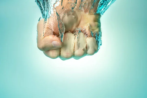 Der Mensch schlug von oben ins Wasser. Die Kraft der Stärke und des Selbstvertrauens. Blauer Hintergrund. — Stockfoto