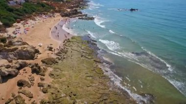 Sahildeki hava fotoğrafçılığı, Portekiz 'deki Gale plajları. Turistler uçurumun kenarında dinlenir..