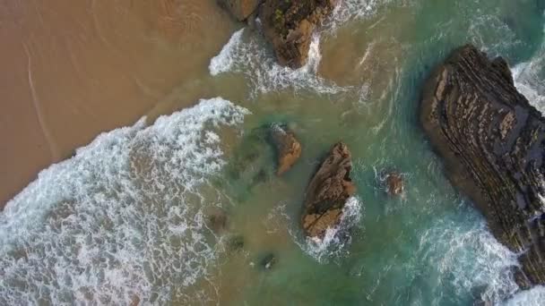 Tournage vidéo aérien. Vagues de l'océan battant sur les rochers sur la plage d'Arrifana, Sagres, Portugal, Algarve . — Video