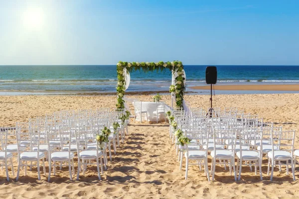 Romantický výhled a květinové dekorace na pláži u moře, pro svatební obřad s květinami. Evropa, Portugalsko, na pozadí jasného slunce. — Stock fotografie