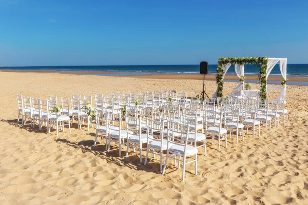Romantik manzara ve deniz kenarındaki kumsalda çiçeklerle yapılan bir düğün töreni için çiçek süslemeleri. Avrupa, Portekiz. — Stok fotoğraf
