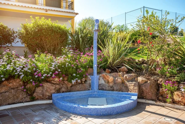 Tradizionale doccia a mosaico in ceramica di design a bordo piscina presso l'hotel. Sullo sfondo del sole splendente . — Foto Stock