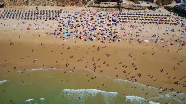 Flygfoto av kusten, stränder i Gale i Portugal Turister vila under paraplyer, simma i klart, turkost vatten. Långsamma rörelser. — Stockvideo